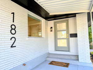 Doorway to property featuring brick siding