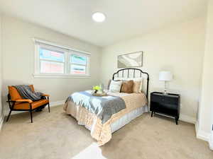 Bedroom featuring light carpet