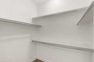 View of primary bedroom walk in closet