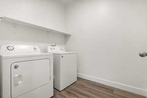 Laundry area featuring washer and dryer and wood finished floors