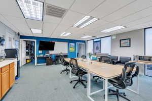 Office space with a paneled ceiling and carpet floors