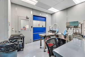 Miscellaneous room with a paneled ceiling and finished concrete floors