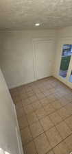 Unfurnished dining area featuring light tile patterned floors and a textured ceiling