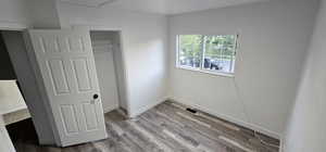 Unfurnished bedroom featuring wood finished floors and a closet