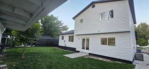 Back of house with a metal roof and a yard