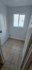 Laundry area with electric dryer hookup, washer hookup, and light tile patterned floors