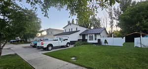 Traditional-style home with a standing seam roof, driveway, and a metal roof