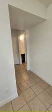 Corridor with light tile patterned floors and baseboards