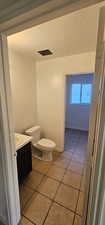 Half bathroom featuring tile patterned floors, vanity, and a textured ceiling