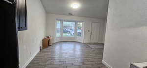 Entrance foyer featuring a textured wall, wood finish floors, and a textured ceiling