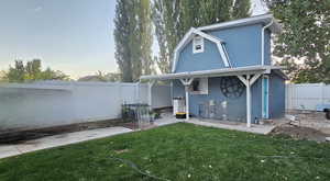 Back of house at dusk with stucco siding and a fenced backyard