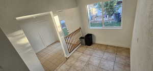 Staircase featuring a textured wall, plenty of natural light, and tile patterned floors