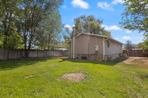 View of side of home with a chimney and a fenced backyard
