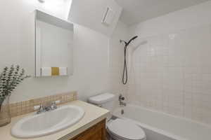 Bathroom with vanity, washtub / shower combination, and tasteful backsplash