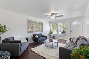 Living room featuring crown molding, dark laminate wood  floors,  ceiling fan