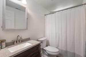 Bathroom with toilet, vanity, tiled tub/shower
