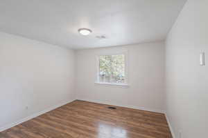 Unfurnished room with dark wood-style flooring and a textured ceiling