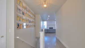 Hall with wood-type flooring, a chandelier, recessed lighting, and an upstairs landing