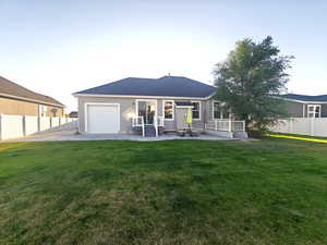 Back of property at dusk featuring a patio area and a garage