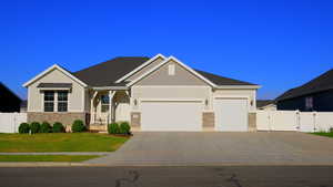 Craftsman-style home featuring a gate, stone siding, an attached garage, and driveway