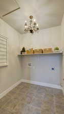 Washroom with a textured ceiling, washer hookup, a chandelier, and electric dryer hookup