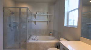 Bathroom with vanity, a garden tub, and a stall shower