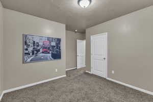 Unfurnished bedroom featuring carpet flooring and a textured ceiling