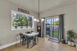 Tiled dining space with a chandelier and a water view
