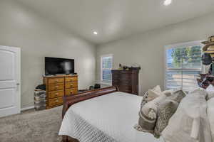 Carpeted bedroom with lofted ceiling and recessed lighting