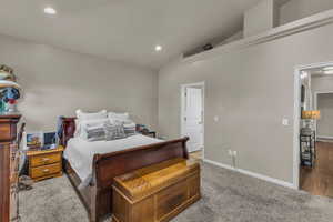 Carpeted bedroom with vaulted ceiling and recessed lighting