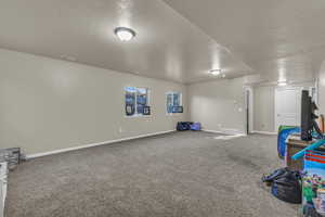 Basement with carpet flooring and a textured ceiling