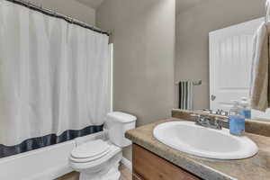 Full bath featuring vanity and shower / bath combination with curtain