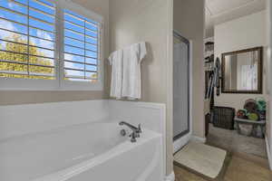 Full bath featuring a shower stall, a bath, and tile patterned flooring