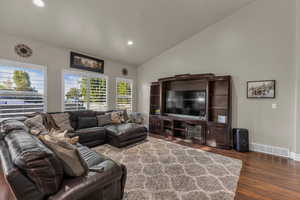 Living room with wood finished floors, vaulted ceiling, and recessed lighting