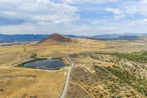 View of mountain backdrop with rural landscape and a large body of water