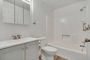 Full bath with vanity, shower / bathtub combination, and wood finished floors