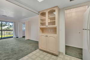 Interior space with light colored carpet, crown molding, and light floors