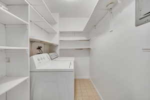 Washroom featuring washer and dryer, light floors, and electric panel