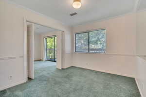 Carpeted bedroom/den featuring ornamental molding and baseboards