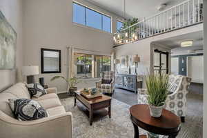 Living area featuring a chandelier and a towering ceiling on first level