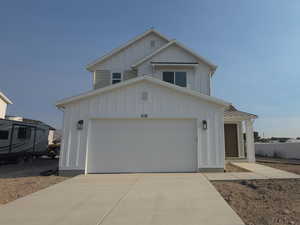 View of front facade featuring board and batten siding and driveway