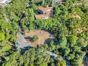 Aerial view of property and surrounding area featuring a forest