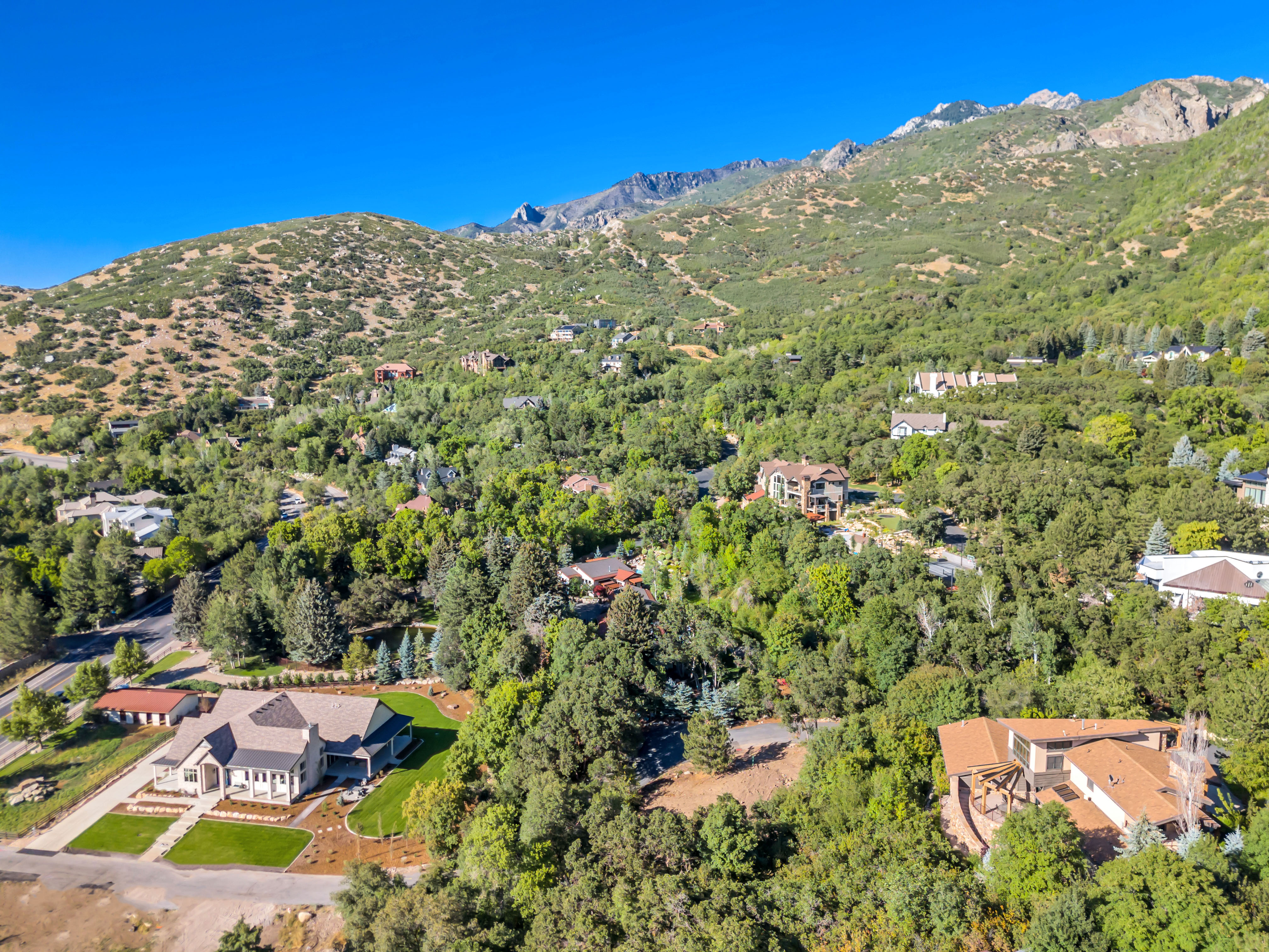 Aerial view of property and surrounding area featuring a mountain backdrop