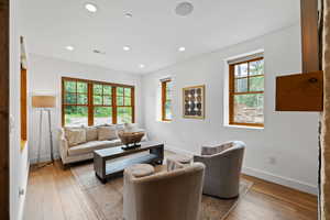 Living room with light wood finished floors and recessed lighting
