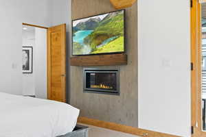 Bedroom featuring a glass covered fireplace