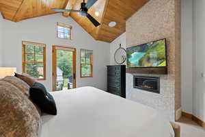 Carpeted bedroom featuring a wood ceiling with exposed beams, access to exterior, a glass covered fireplace, high vaulted ceiling, and a ceiling fan