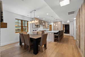 Dining room with light wood-type flooring and recessed lighting