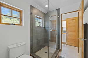 Full bathroom featuring toilet and a stall shower
