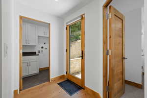 Doorway to outside featuring light wood-style flooring and baseboards