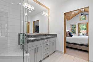 Full bathroom featuring connected bathroom, double vanity, wood ceiling, and a shower stall